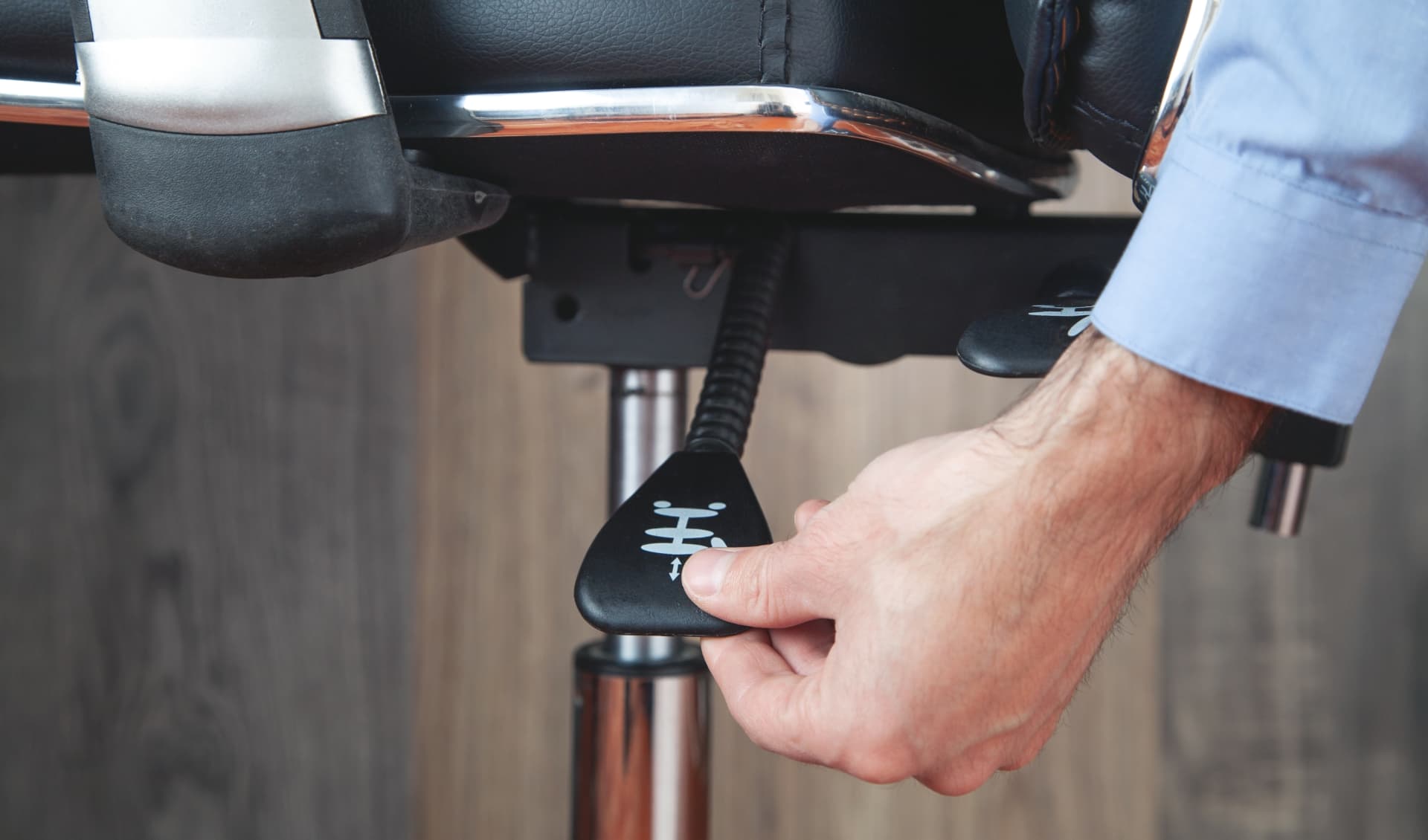 Hånd justerer højden på en ergonomisk kontorstol